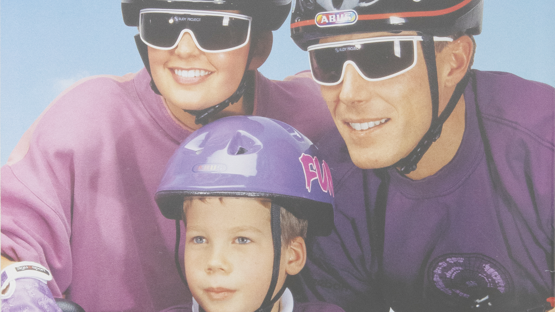 En man och två barn med cykelhjälmar från ABUS © ABUS